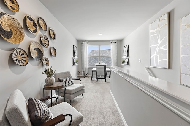 living area featuring light colored carpet and baseboards