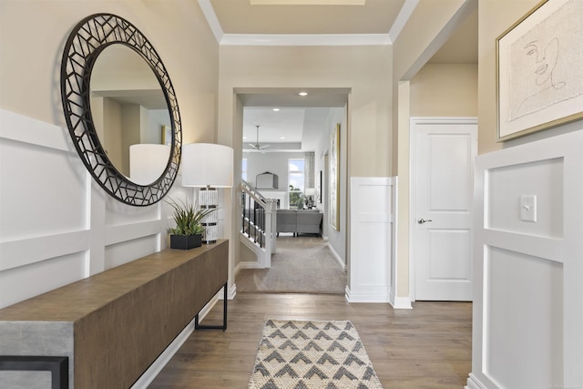 foyer entrance featuring stairs, ceiling fan, wood finished floors, and crown molding