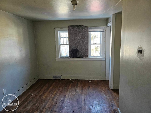 empty room with visible vents and dark wood-type flooring