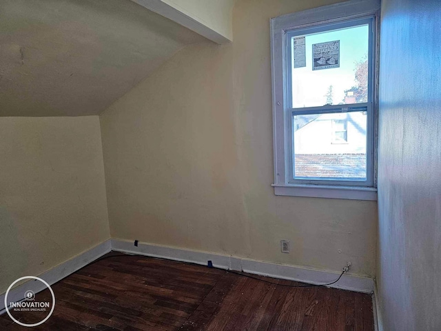 additional living space with dark wood-style flooring, vaulted ceiling, and baseboards