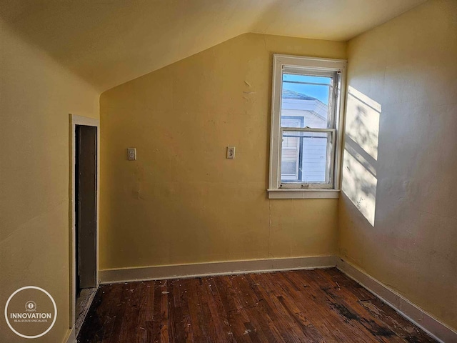 bonus room with dark wood-style floors, baseboards, and vaulted ceiling