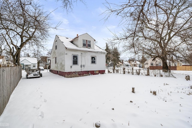 snow covered property featuring fence