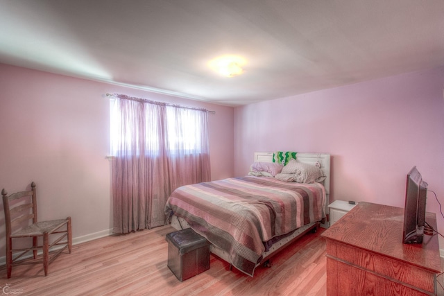 bedroom with light wood-type flooring and baseboards