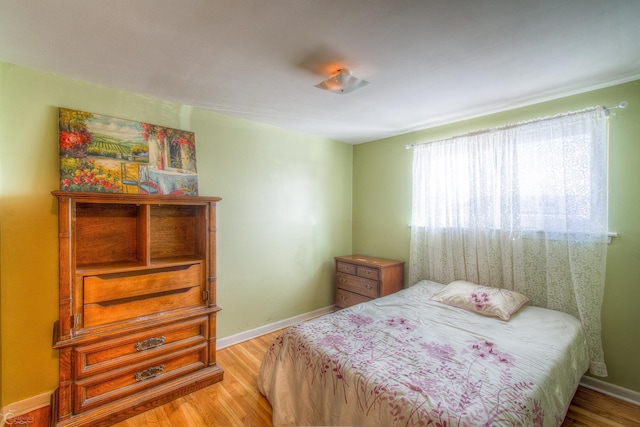 bedroom with baseboards and wood finished floors