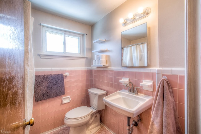 full bath featuring a wainscoted wall, toilet, and tile walls