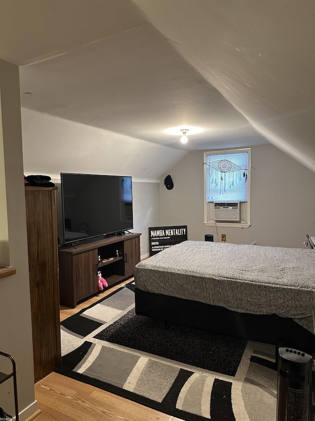 bedroom featuring cooling unit, vaulted ceiling, and light wood-style flooring