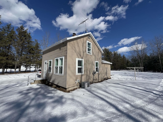 snow covered property featuring central AC