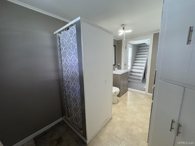 bathroom with ornamental molding, baseboards, toilet, and tile patterned floors