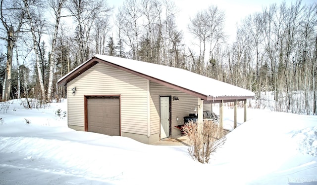 snow covered garage featuring a garage