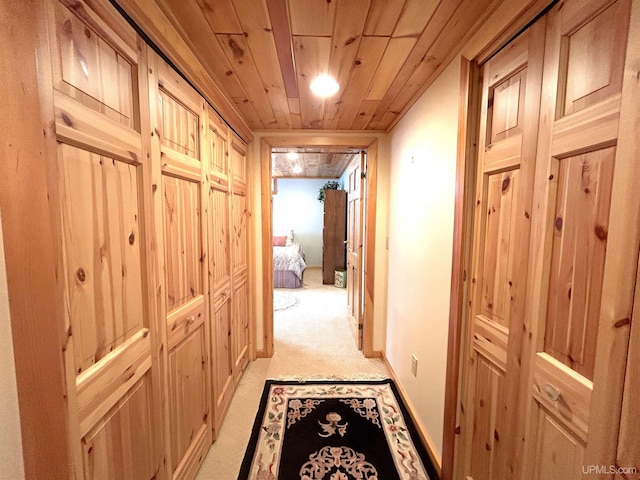 hallway featuring light carpet and wood ceiling