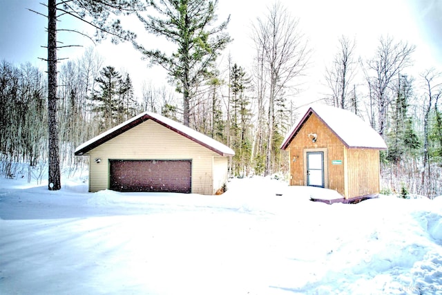 snow covered garage with a detached garage