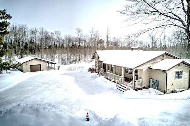 view of front facade with a porch, an outbuilding, and a detached garage