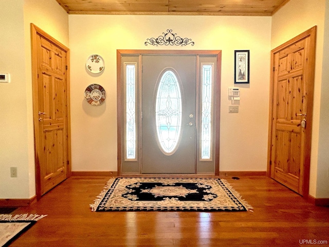 entrance foyer with crown molding, baseboards, and wood finished floors