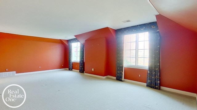 bonus room featuring light carpet, baseboards, visible vents, and lofted ceiling