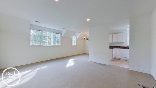 interior space featuring light colored carpet, visible vents, baseboards, and an inviting chandelier