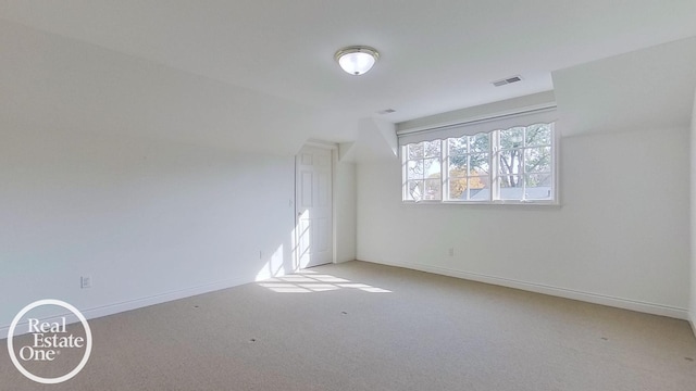 empty room featuring visible vents, light carpet, and baseboards