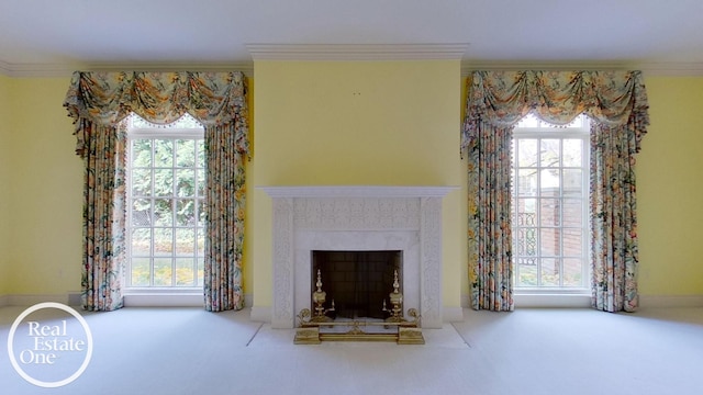 unfurnished living room featuring carpet floors, ornamental molding, and a healthy amount of sunlight