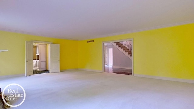 unfurnished room with baseboards, visible vents, stairway, and carpet flooring