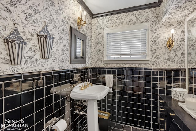 bathroom with wallpapered walls, crown molding, tile walls, and a wainscoted wall