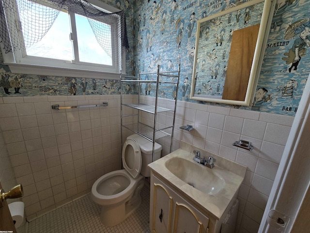 bathroom featuring wainscoting, tile patterned flooring, vanity, and wallpapered walls