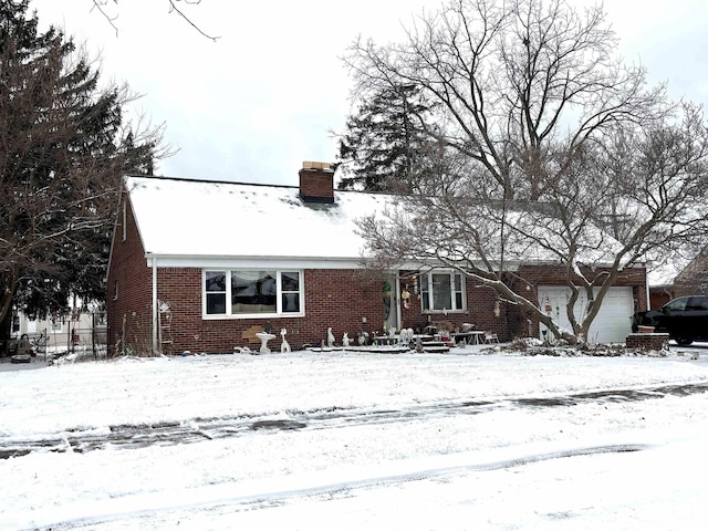 view of front facade with a garage, a chimney, and brick siding