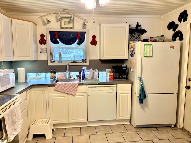 kitchen featuring white appliances, dark countertops, a sink, and white cabinets