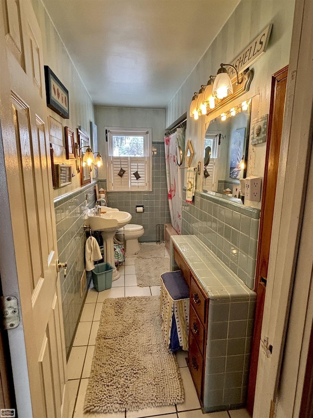 full bath featuring toilet, a shower with shower curtain, tile patterned flooring, and tile walls