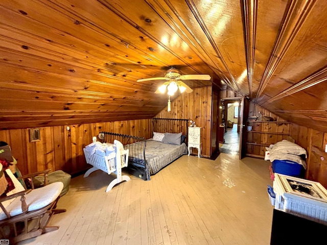 unfurnished bedroom with wood walls, wood ceiling, vaulted ceiling, and light wood finished floors