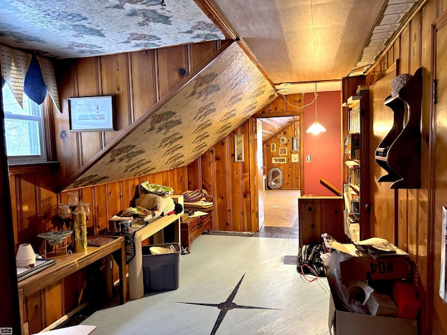 additional living space with vaulted ceiling, light wood finished floors, and wood walls