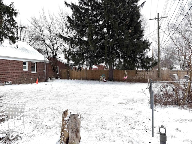 yard layered in snow featuring fence