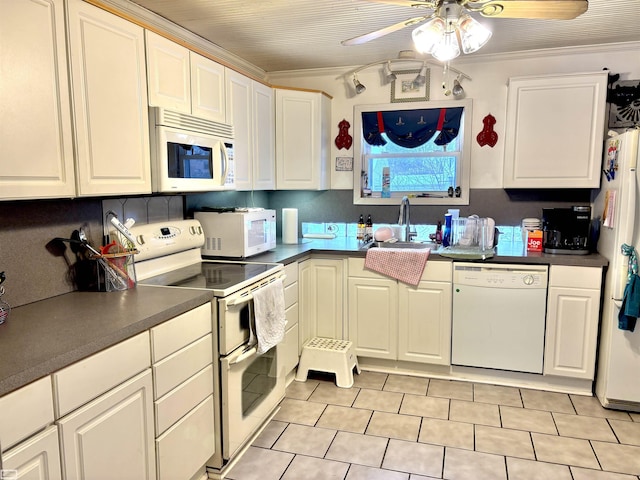 kitchen featuring dark countertops, white appliances, and white cabinets