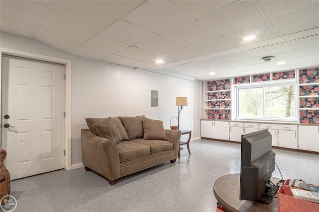 living room featuring light speckled floor, a paneled ceiling, visible vents, electric panel, and baseboards