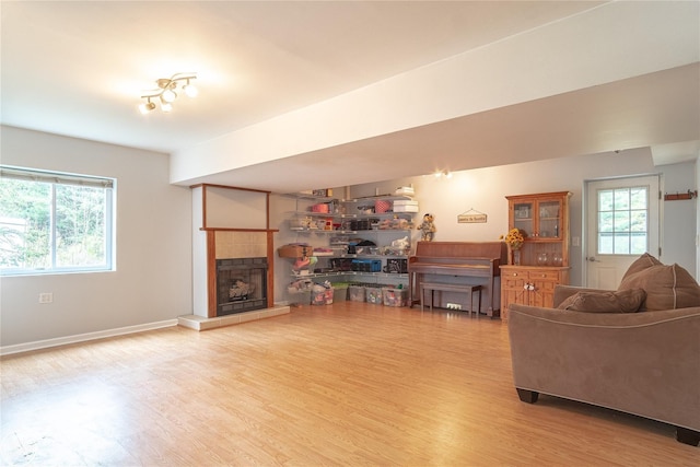 living room with a tile fireplace, wood finished floors, and baseboards