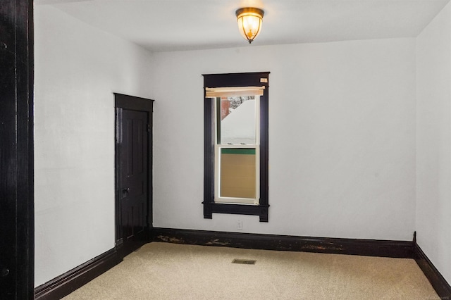 carpeted spare room with visible vents and baseboards