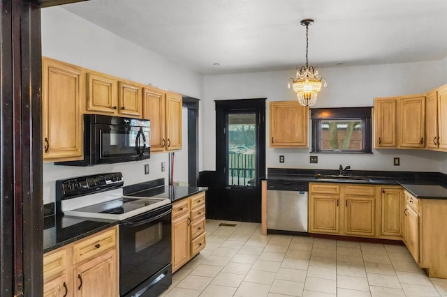 kitchen featuring dark countertops, black appliances, a sink, and decorative light fixtures