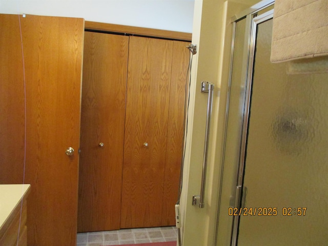 full bathroom featuring a shower stall, a closet, and vanity