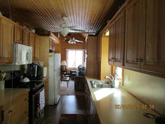 kitchen featuring white appliances, brown cabinetry, dark tile patterned flooring, light countertops, and a sink