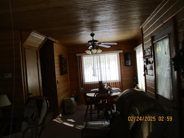 dining space with wood ceiling, wooden walls, and ceiling fan