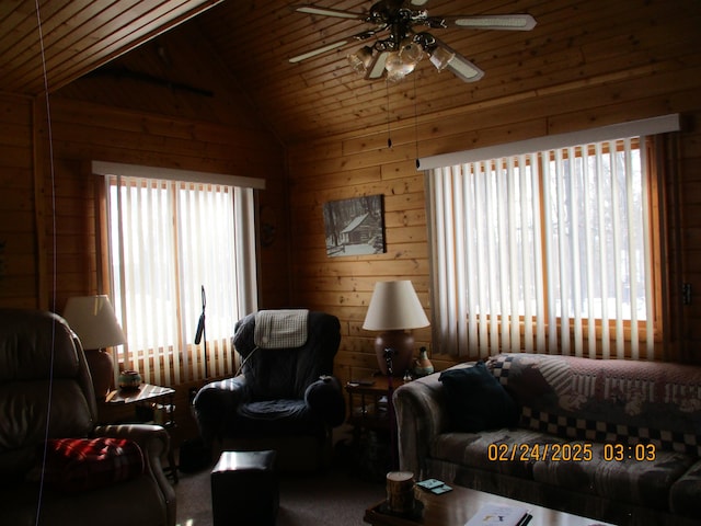 living area featuring vaulted ceiling, ceiling fan, wooden ceiling, and wooden walls