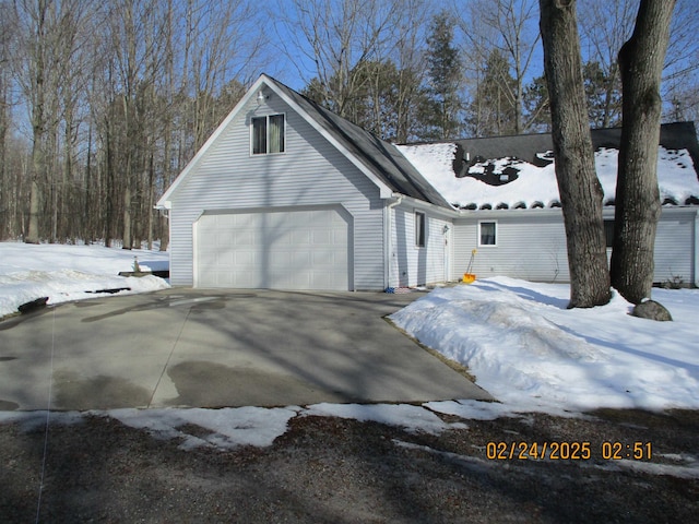 view of snowy exterior featuring concrete driveway