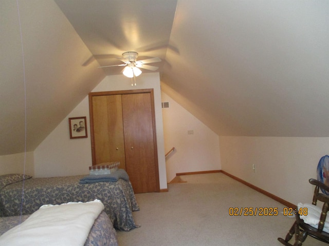 bedroom featuring light colored carpet, visible vents, baseboards, vaulted ceiling, and a closet