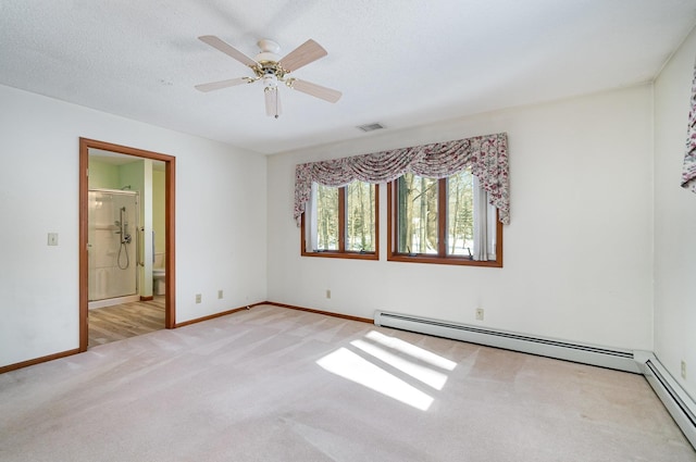 spare room with baseboards, visible vents, baseboard heating, and light colored carpet