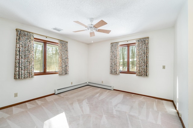 spare room featuring light carpet, a wealth of natural light, and visible vents