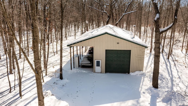 snow covered garage with a detached garage