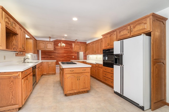 kitchen with a kitchen island, brown cabinets, light countertops, black appliances, and a sink