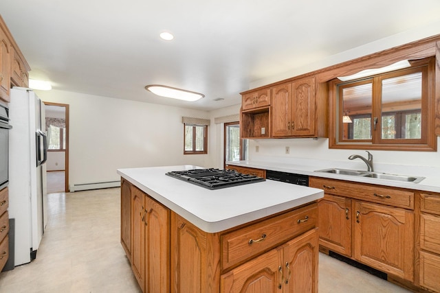 kitchen featuring stainless steel gas cooktop, light floors, light countertops, a kitchen island, and a sink