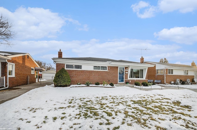 single story home featuring a chimney and brick siding