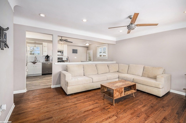 living area featuring plenty of natural light, dark wood finished floors, and baseboards