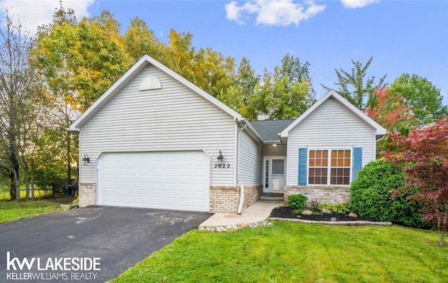 single story home featuring a garage, brick siding, a front lawn, and aphalt driveway