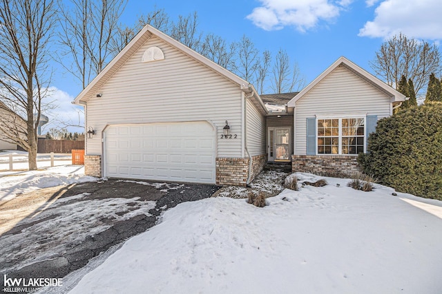 ranch-style house with an attached garage, fence, and brick siding